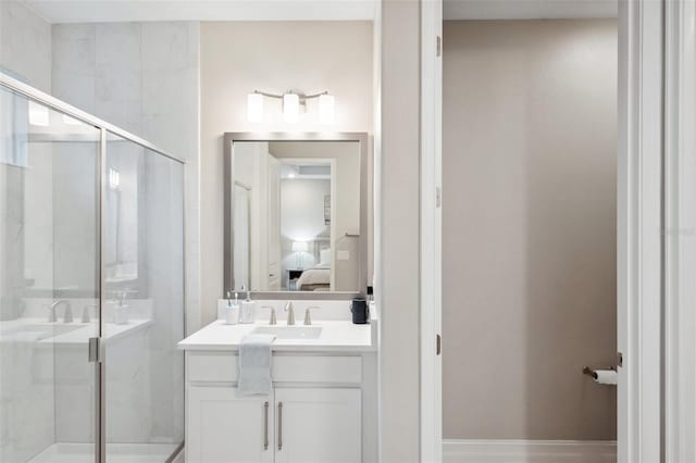 ensuite bathroom featuring vanity, baseboards, a stall shower, and ensuite bathroom