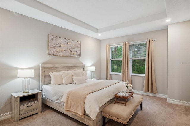 carpeted bedroom with recessed lighting, baseboards, and a raised ceiling