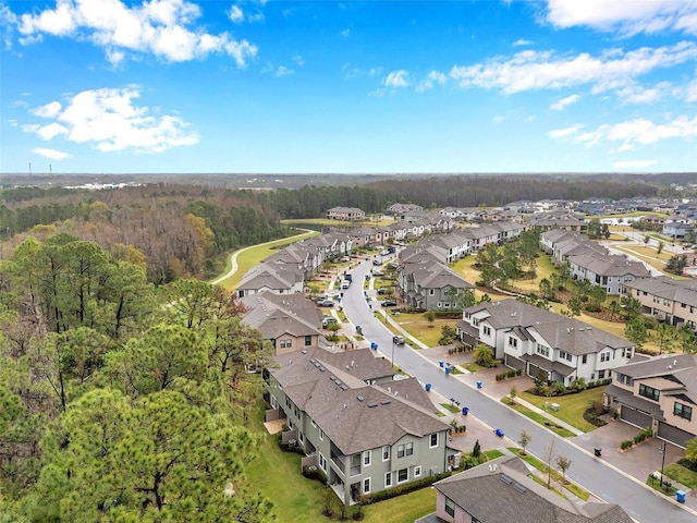 drone / aerial view with a residential view and a view of trees