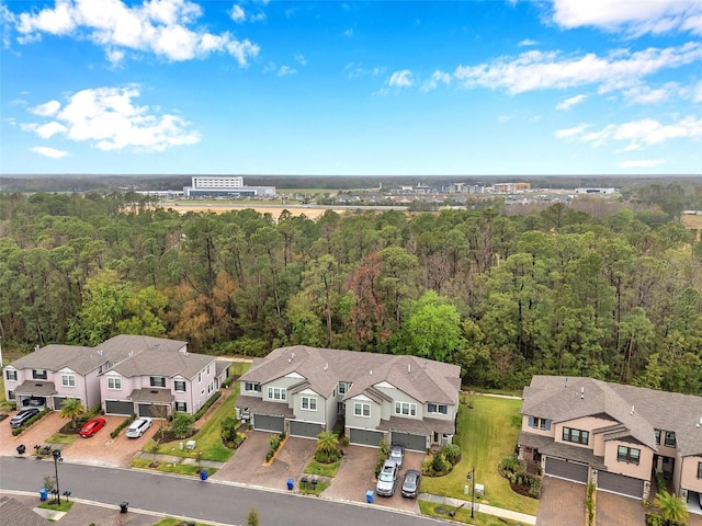 drone / aerial view featuring a residential view and a view of trees