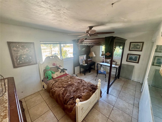 bedroom featuring light tile patterned flooring, a ceiling fan, and baseboards