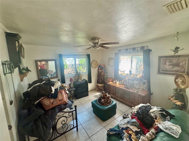 living area with ceiling fan, visible vents, a textured ceiling, and light tile patterned flooring