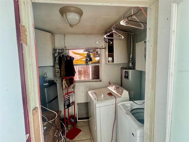 clothes washing area with washer and clothes dryer, laundry area, tile patterned floors, and water heater