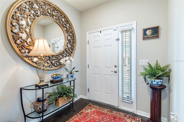 entryway with baseboards and dark wood-style flooring