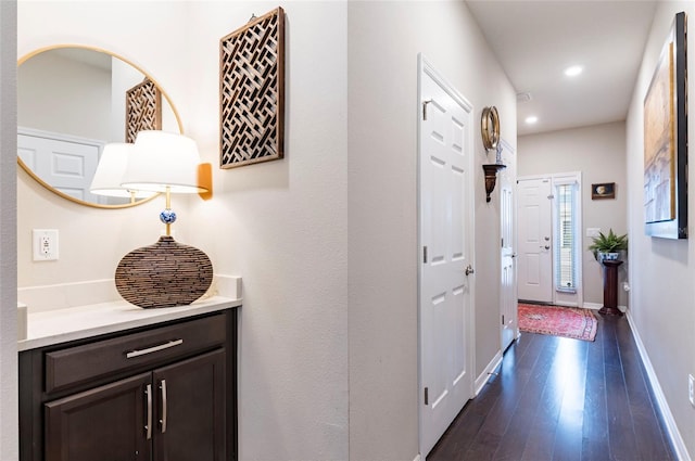 hall featuring recessed lighting, baseboards, and dark wood-style flooring