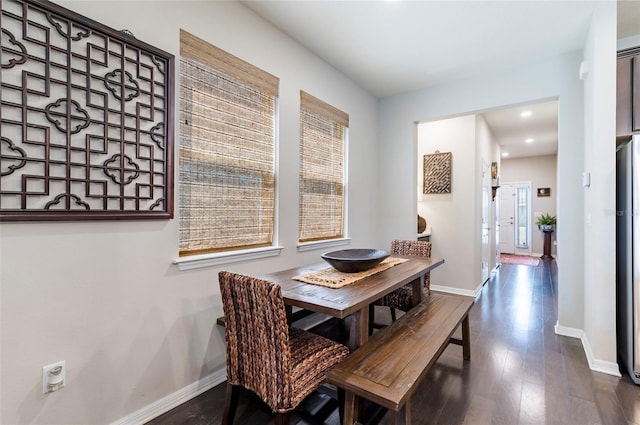 dining space with dark wood-style floors, baseboards, and a wealth of natural light