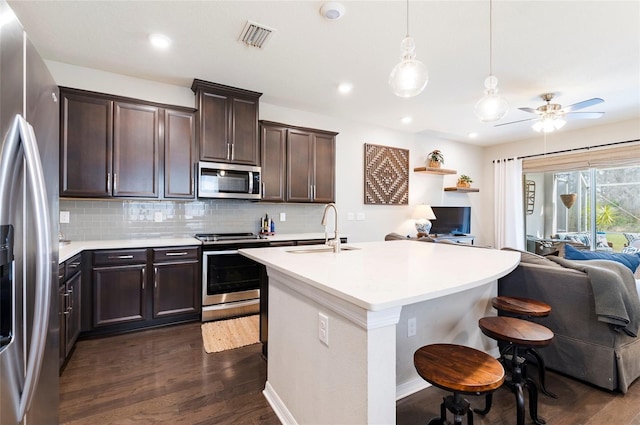 kitchen with visible vents, dark wood finished floors, a sink, appliances with stainless steel finishes, and open floor plan