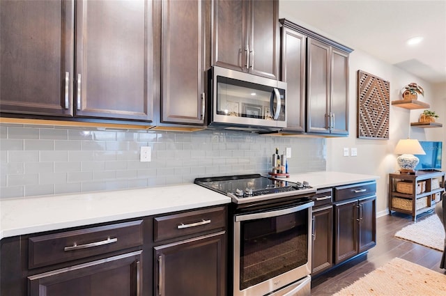 kitchen featuring dark brown cabinets, backsplash, appliances with stainless steel finishes, and light countertops