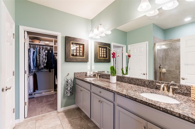 full bathroom featuring a sink, a spacious closet, a stall shower, and double vanity