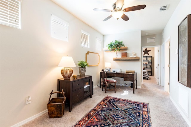 home office with ceiling fan, light colored carpet, visible vents, and baseboards