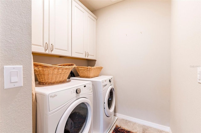 laundry room featuring baseboards, cabinet space, and washing machine and dryer