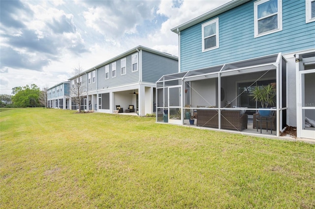 back of house featuring a yard, a patio, and glass enclosure