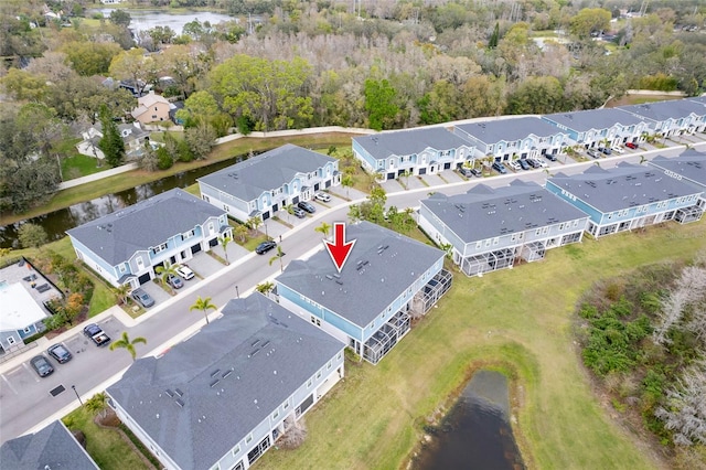 drone / aerial view featuring a residential view and a water view