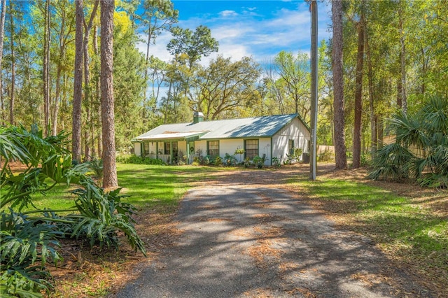 view of front of house featuring a front lawn and dirt driveway