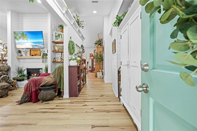 entrance foyer with light wood-type flooring and a large fireplace