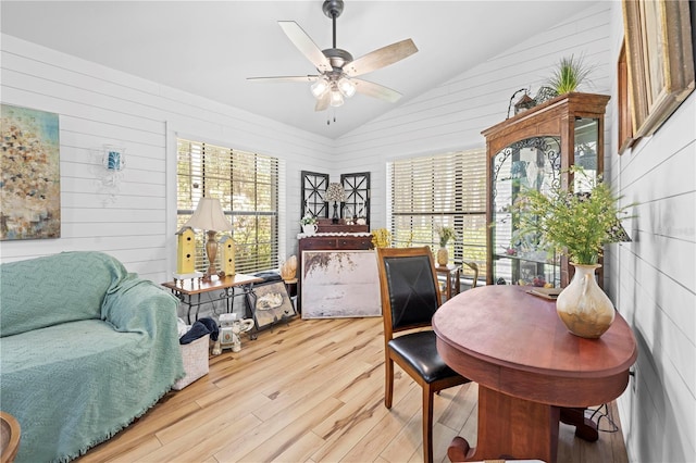 home office featuring ceiling fan, light wood-style floors, and vaulted ceiling