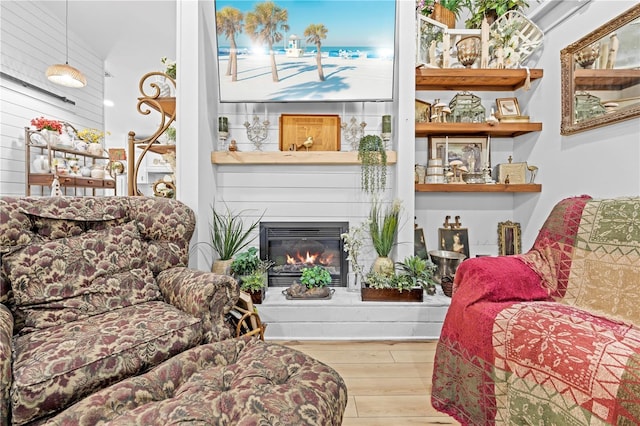 living room featuring a glass covered fireplace and wood finished floors