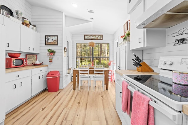 kitchen featuring visible vents, under cabinet range hood, light countertops, vaulted ceiling, and electric range