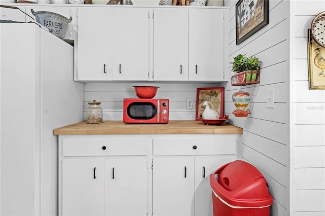 kitchen with white cabinets, freestanding refrigerator, and light countertops