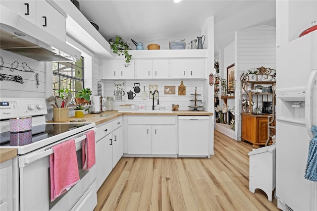 kitchen with under cabinet range hood, white appliances, white cabinets, and a sink