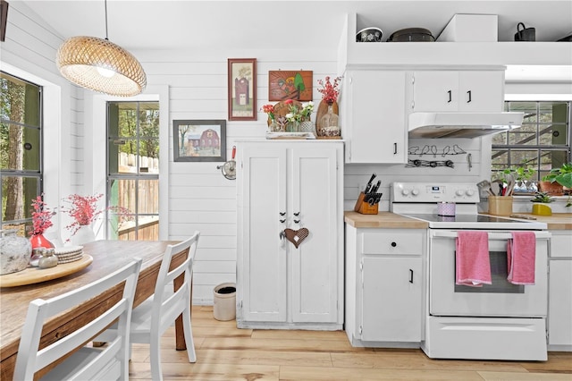 kitchen with under cabinet range hood, light wood-style floors, light countertops, and electric stove