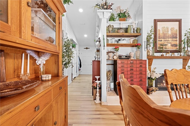 interior space with a glass covered fireplace, recessed lighting, and light wood-type flooring