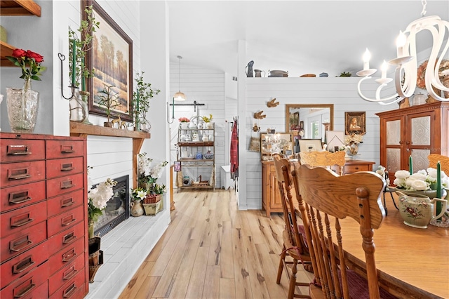 dining room featuring a glass covered fireplace and light wood finished floors