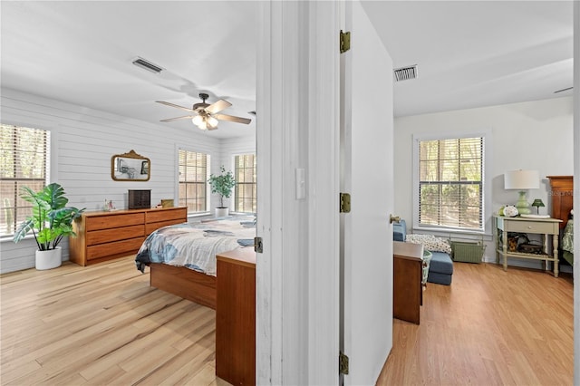 bedroom with visible vents, wood finished floors, and radiator heating unit