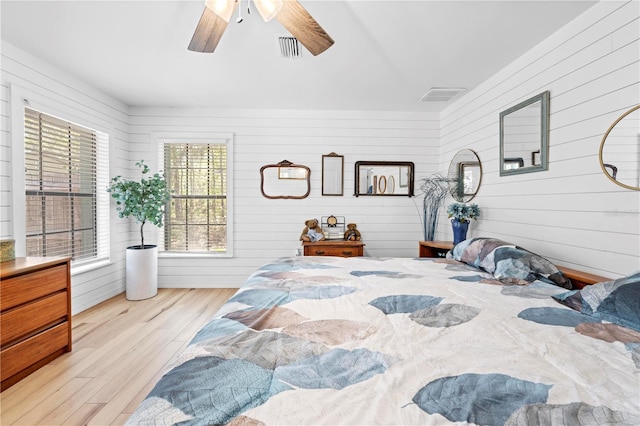 bedroom featuring a ceiling fan, wood finished floors, and visible vents