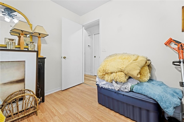 living area featuring baseboards, wood finished floors, and a ceiling fan