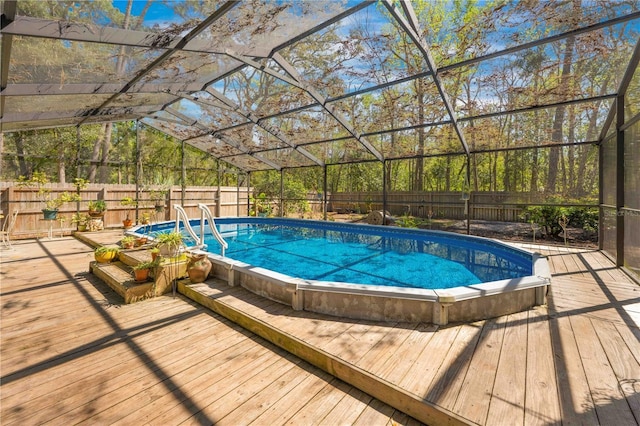 view of swimming pool featuring a lanai, a fenced backyard, a fenced in pool, and a wooden deck