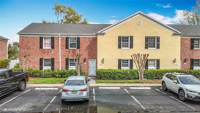 view of property featuring stucco siding and uncovered parking