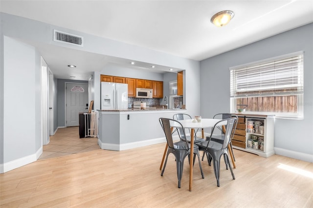 dining space with visible vents, baseboards, and light wood-style floors