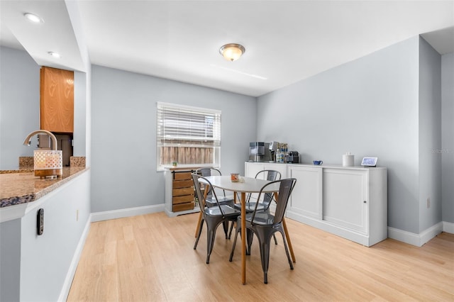 dining room with light wood-style floors and baseboards