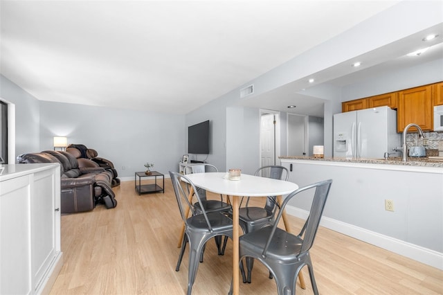 dining area with light wood finished floors, visible vents, recessed lighting, and baseboards