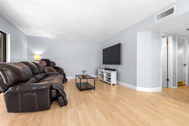 living room with baseboards, visible vents, and light wood-type flooring