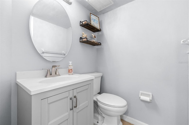 half bath with visible vents, toilet, vanity, and baseboards