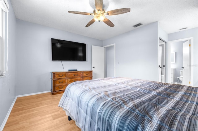 bedroom featuring visible vents, baseboards, a textured ceiling, and light wood finished floors