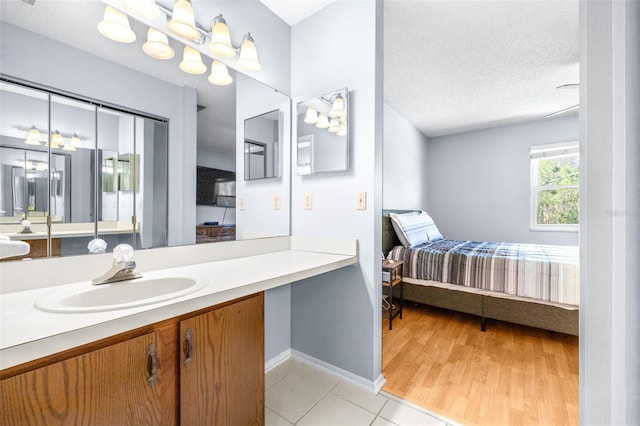 ensuite bathroom featuring vanity, ensuite bath, tile patterned floors, and a textured ceiling