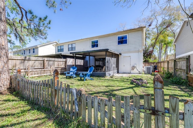 rear view of property with a yard, central AC, a fenced backyard, and a sunroom