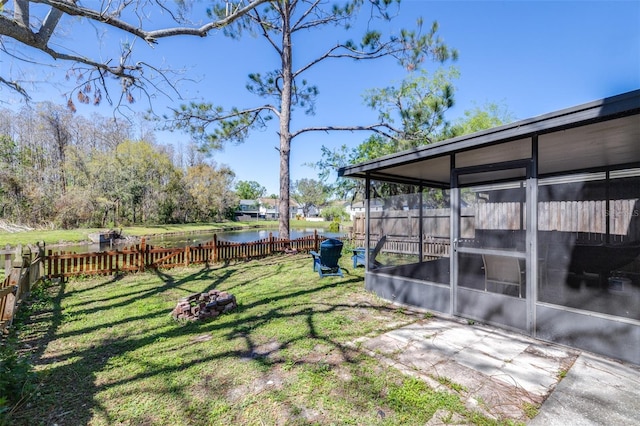 view of yard featuring a water view, fence private yard, and a sunroom