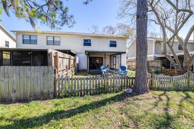 back of property with a sunroom and a fenced front yard