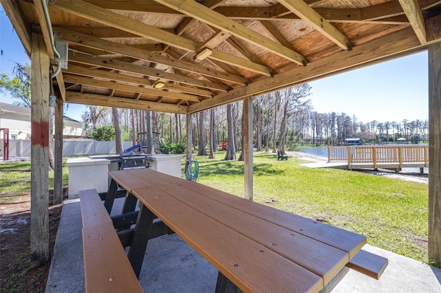 view of dock with a yard and fence