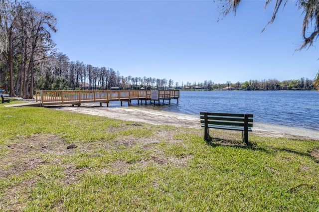 dock area with a yard and a water view