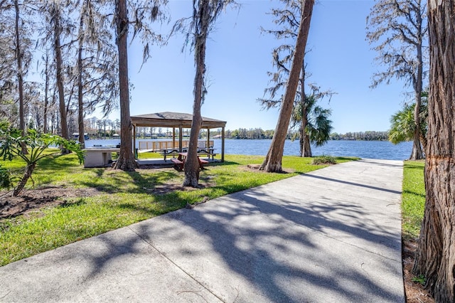 view of property's community with a yard and a water view