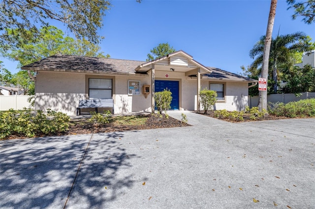 ranch-style house with stucco siding, concrete driveway, an attached garage, and fence