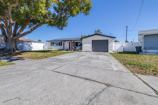 single story home with a gate, concrete driveway, a front lawn, and fence