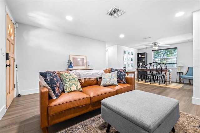 living area with a ceiling fan, wood finished floors, visible vents, baseboards, and recessed lighting