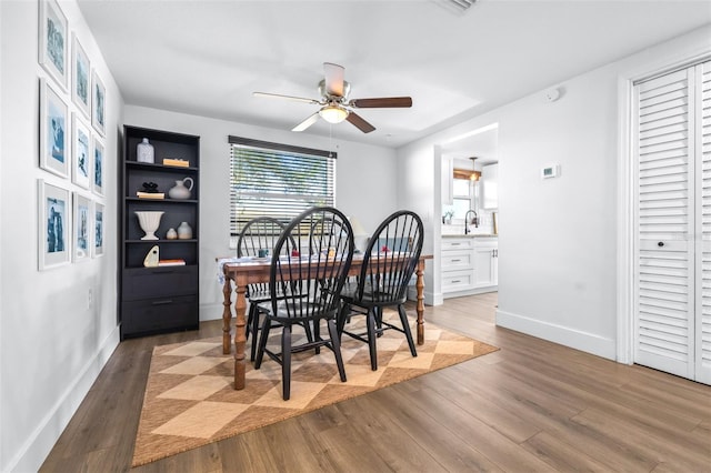 dining area with ceiling fan, baseboards, and wood finished floors