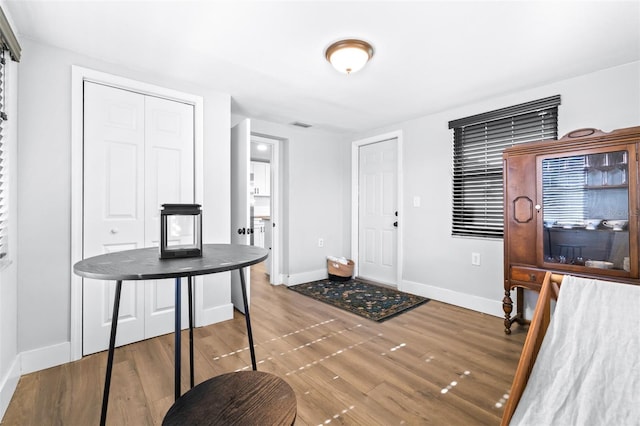 office space featuring visible vents, baseboards, and wood finished floors